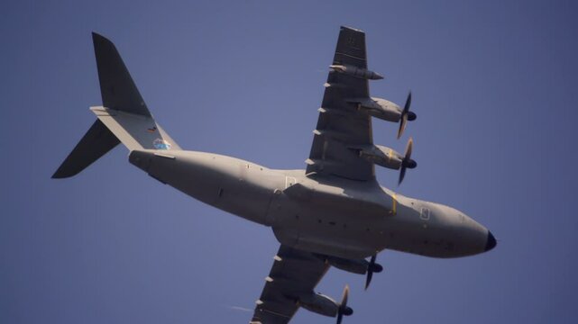 Close-up shot of the German Airbus A400M Atlas military transport aircraft flying overhead, showcasing the aircraft's design and propellers in motion. Filmed during the Airborne event in Oosterbeek.