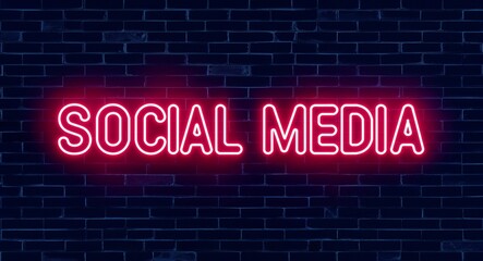 Fototapeta premium social media word lettering glowing with neon light on dark brick wall background