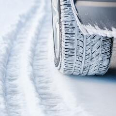  ice car tire on road, winter tread pattern leaving tracks in snow, vehicle wheel showcasing safety and traction challenges in frozen driving conditions