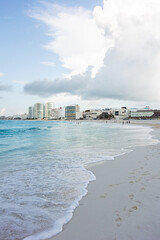 Playa y mar con edificios y personas en el fondo