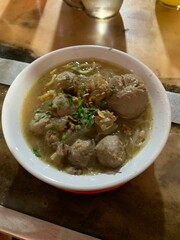 Bowl with tasty meatball soup and ingredients potatoes, spices and vegetables on wooden table. Top view. selective focus.