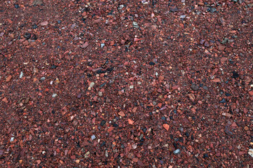 Decorative uniform coating of red crushed stone.