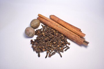 cinnamon sticks, nutmeg and cloves on white background