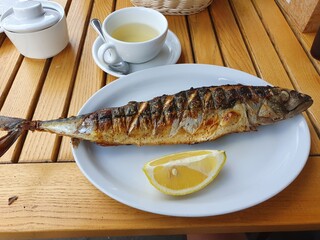 Baked mackerel on a plate. Mackerel with lemon.