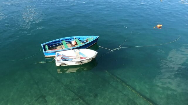 Peque&ntilde;as y viejas barcas de remos fondeadas en el puerto pesquero de Luarca, Espa&ntilde;a. Sin sonido
