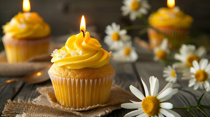 cupcakes with candle, Small bright yellow cupcakes decorated with burning candle and fresh chamomile.