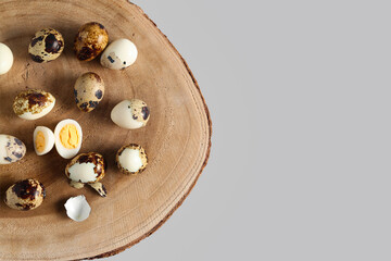 Wooden board with fresh boiled quail eggs on grey background