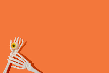 Skeleton hands are holding eyeball, minimal scarey halloween idea.