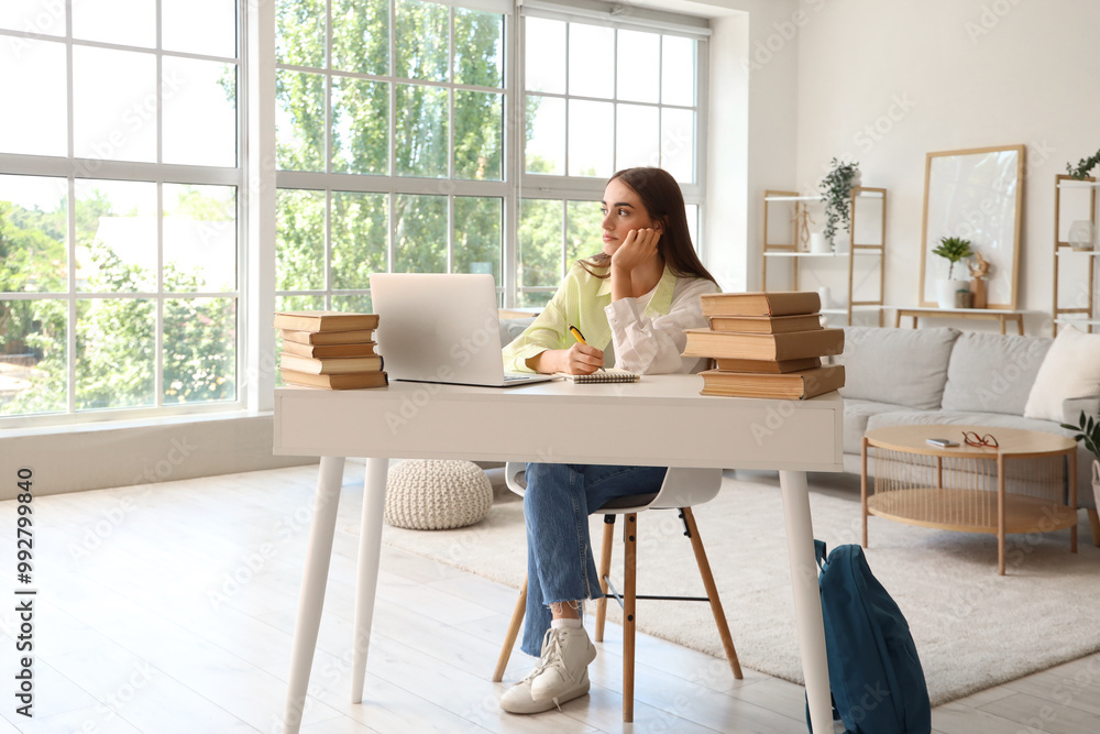 Sticker Tired female student with books, notebook and laptop studying at home