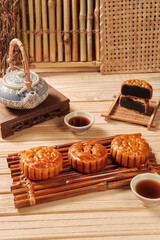 Mooncakes and teacups on wooden tray, suitable for MidAutumn Festival or Chinese culturethemed designs and concepts.