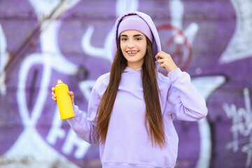 Teenage girl with spray paint outdoors