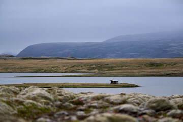 Lonely house on shore of lake in fog