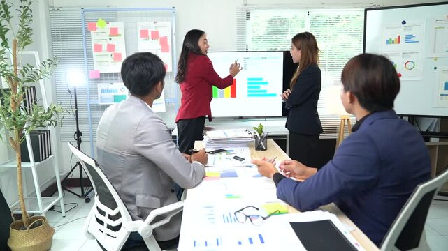 Business team engages in a dynamic discussion about financial charts during a meeting. Ideas flow as team members analyze data and strategize for future success