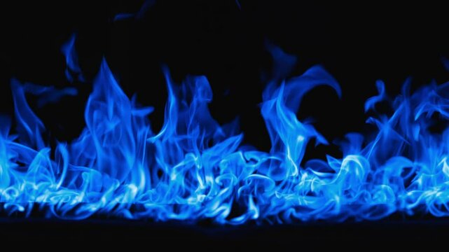 Gas burns with a bright blue flame. Beautiful dancing fire, Lots of fire. Blue fire is burning. Bright blue flames. A wall of real fire, abstract background. Super-slow motion video