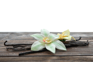 Aromatic vanilla pods and flowers on table against white background