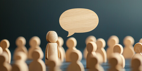A single wooden figure with a speech bubble stands out among a crowd, symbolizing public speaking, leadership, and communication.