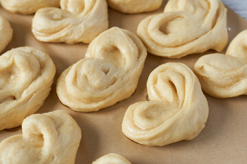 Yeast dough for buns. Heart-shaped buns on parchment.