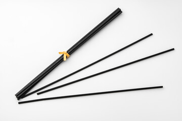 Black aromatic sticks resting on a plain white background