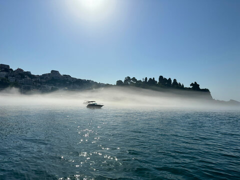 Fog mist above sea and town at morning.