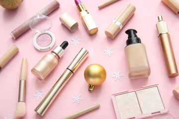 Beautiful Christmas decorations with different makeup products on pink background