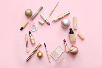 Frame made of makeup products and Christmas decorations on pink background