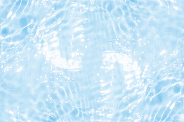 Blue water with ripples on the surface. Defocus blurred transparent blue colored clear calm water surface texture with splashes and bubbles. Water waves with shining pattern texture background.