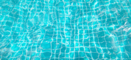 Blurred image of water and tiles in pool. Water waves and reflection in swimming pool