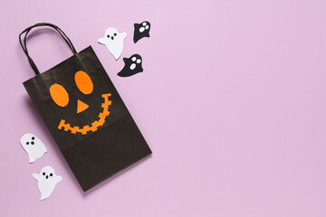 Composition with Halloween shopping bag and paper ghosts on pink background