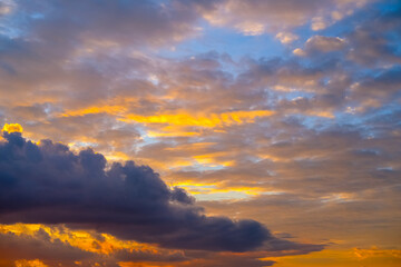 Dramatic sunset paints the sky with vibrant shades of orange, pink, and dark purple, silhouetting...