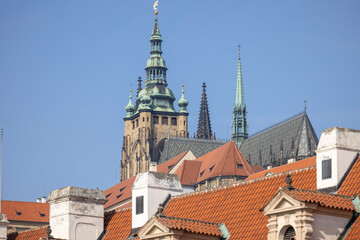 Obraz premium View of Hradcany hill with towers of St. Vitus Cathedral on background of blue sky, Prague, Czech Republic