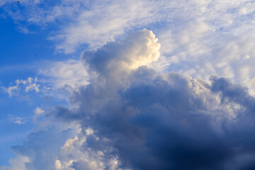 Clear blue sky with fluffy white and gray clouds creating a dynamic, textured atmosphere, showcasing the natural beauty of an expansive sky on a bright day.