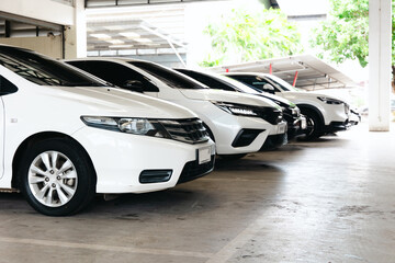 Underground parking garage with cars lined up in a modern, well-lit concrete area. The urban area has rows of parking spaces, providing an organized storage area for cars.