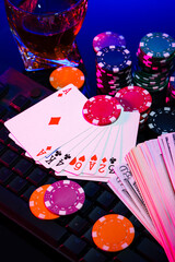 Game chips and cash on a dimly lit keyboard during an exciting gaming night at home