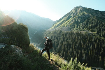 Adult man hiking through scenic mountains with a backpack on his back