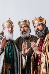 Three wise men in crowns gesturing upward in surprise