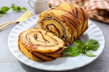 Coffee break roll cake in a white plate on grey background,