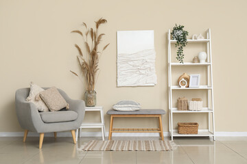 Interior of light room with armchair, bench and shelving unit