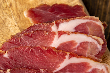 a piece of cured pork ham with thin layers of lard on the table