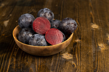 cut purple plums on the table during cooking