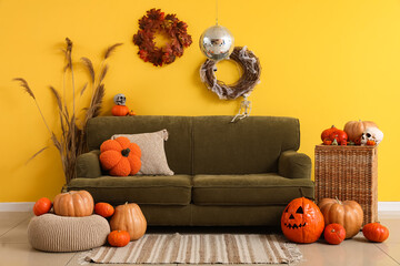 Stylish living room with disco ball and green sofa decorated for Halloween party
