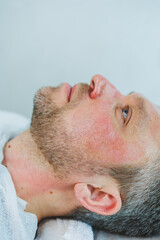 Naklejka premium Male cosmetology. A man lies at a cosmetologist for a facial treatment.