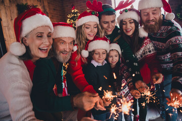 Portrait of friendly peaceful family have fun hold sparklers gather celebrate new year xmas flat indoors