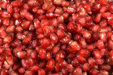 pomegranate seeds on black slate background