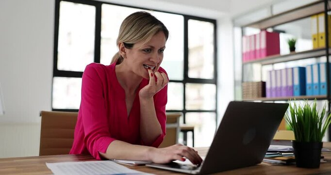 Worrying young employee waits for result of interview with new boss. Lady bites nails in excitement while sits at laptop on table. Bad habit concept