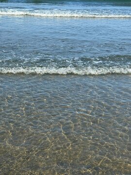 Gentle waves on sandy beach. 