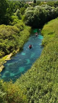 In canoa risalendo il fiume Tirino in Abruzzo, Italia.
Vista aerea dei canoisti che remano risalendo la corrente del fiume. Ripresa Verticale.
