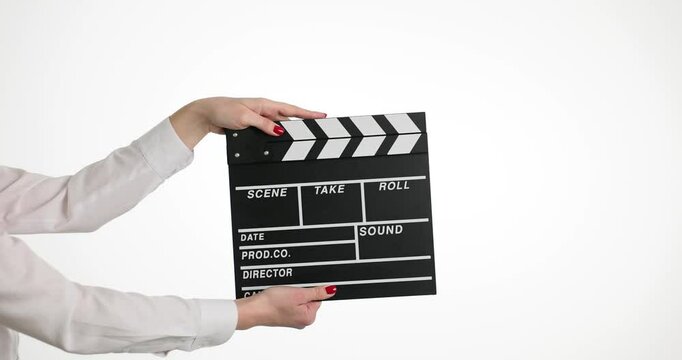 Female hands clip using black clapboard to give signal to start shooting film. Woman assistant against isolated white background during set
