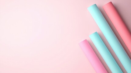 Obraz premium A minimalist arrangement of pastel-colored rolls on a soft pink background, evoking a calm and creative atmosphere.