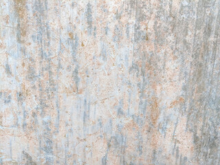Fototapeta premium Weathered surface with vertical streaks and faded spots in light gray and beige tones. The textured wall showcases signs of aging, roughness, and subtle color variations in an abstract pattern.