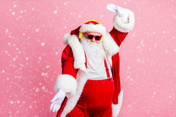 Photo of funky cool santa claus have x-mas newyear celebration listen jolly songs headphones raise hands wear suspenders pants sunglass isolated over pastel color background